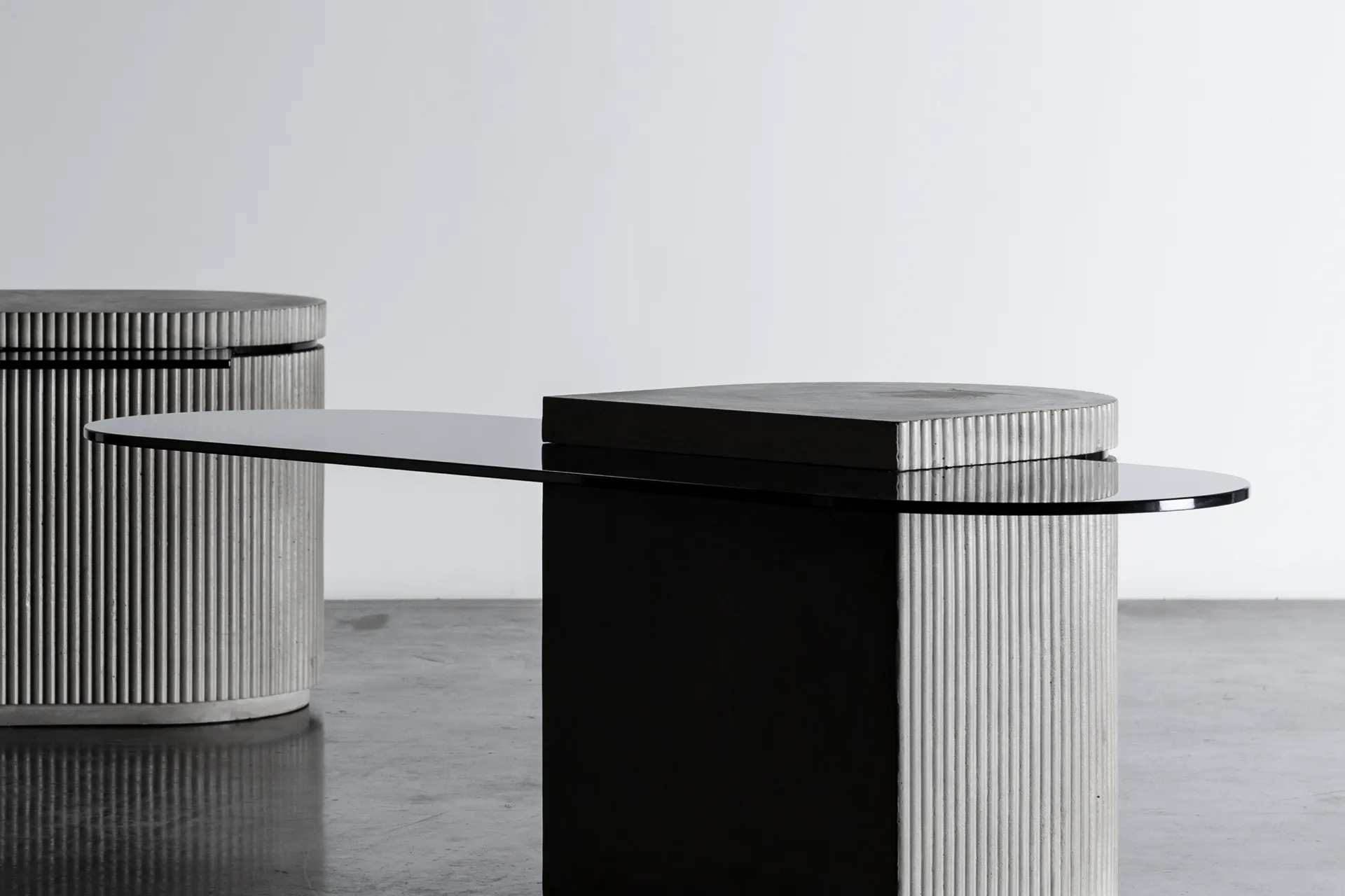 Concrete and hybrid glass cabinet between a coffee table and an extra table