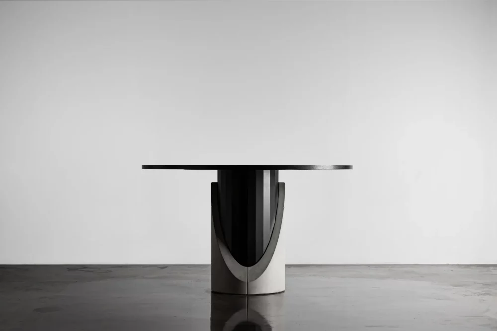 Dining table with a concrete base and black oak plated tabletop