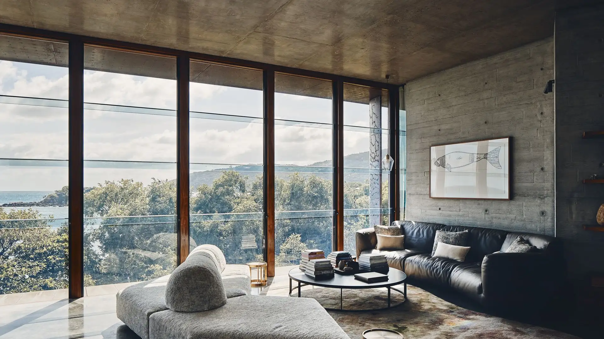 Contemporary living room with brutalist furniture and panoramic floor-to-ceiling window