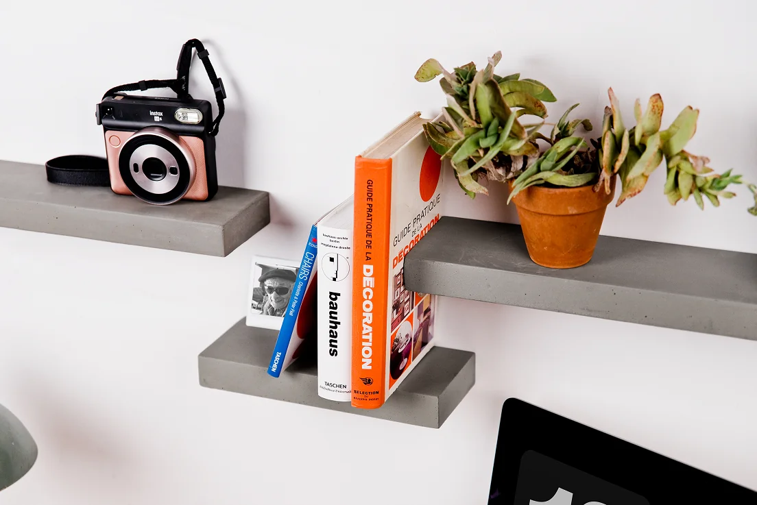 Sliced concrete wall shelves above a wooden desk